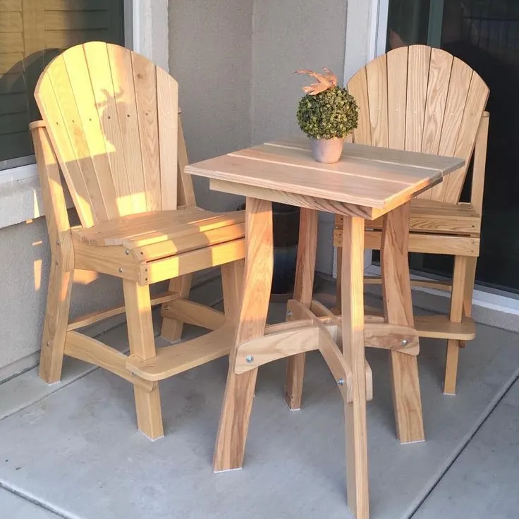 Pair of tall fan-back outdoor chairs in light timber with a matching bar-height table on a patio