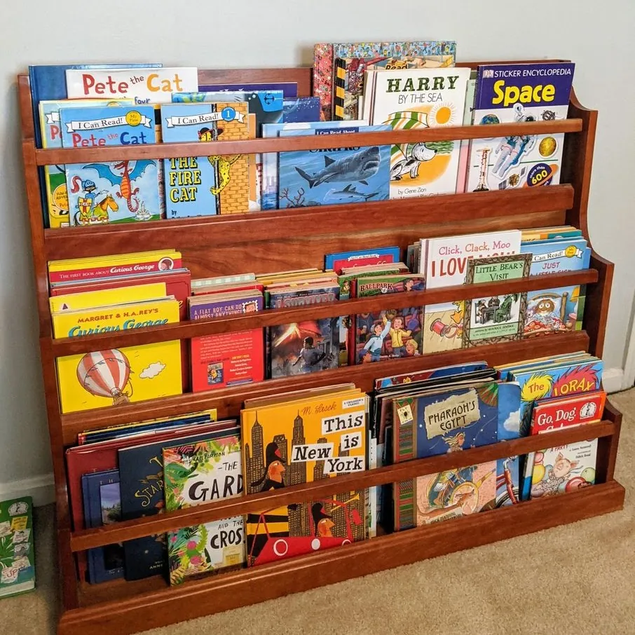 Cherry-stained front-facing bookshelf with four tiers full of picture books