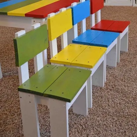 Row of kids' chairs with white frames and green, yellow, blue and red painted seats and backs