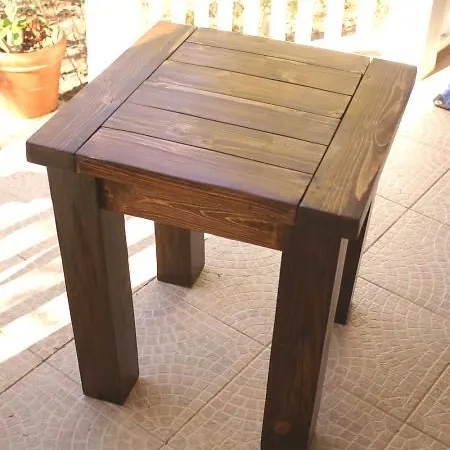 Square side table in dark walnut-look stain with a slatted breadboard top on a tiled patio