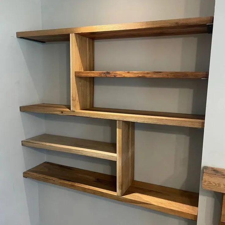 Oak staggered alcove shelves with offset vertical dividers on a grey wall