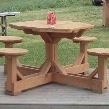 Octagonal outdoor table in honey-stained timber with four round stools joined to the base