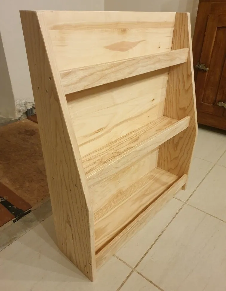 Natural pine front-facing book rack with three ledges and angled sides