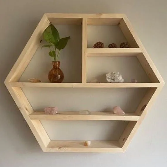 Pine hexagon shelf with divided compartments holding a plant and crystals