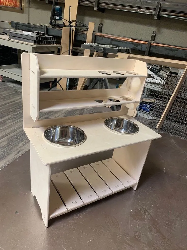 Pale plywood mud kitchen with two steel bowls, a two-tier back shelf and slatted lower shelf