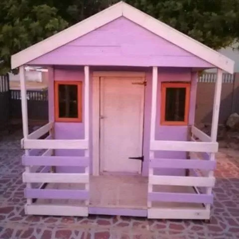 Purple and white Wendy house with orange window frames, small front veranda and railings