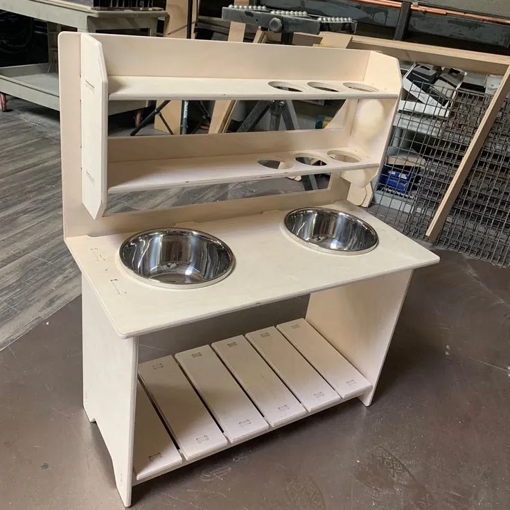 Unfinished plywood mud kitchen with two steel bowl sinks, cut-out shelves and a slatted lower shelf