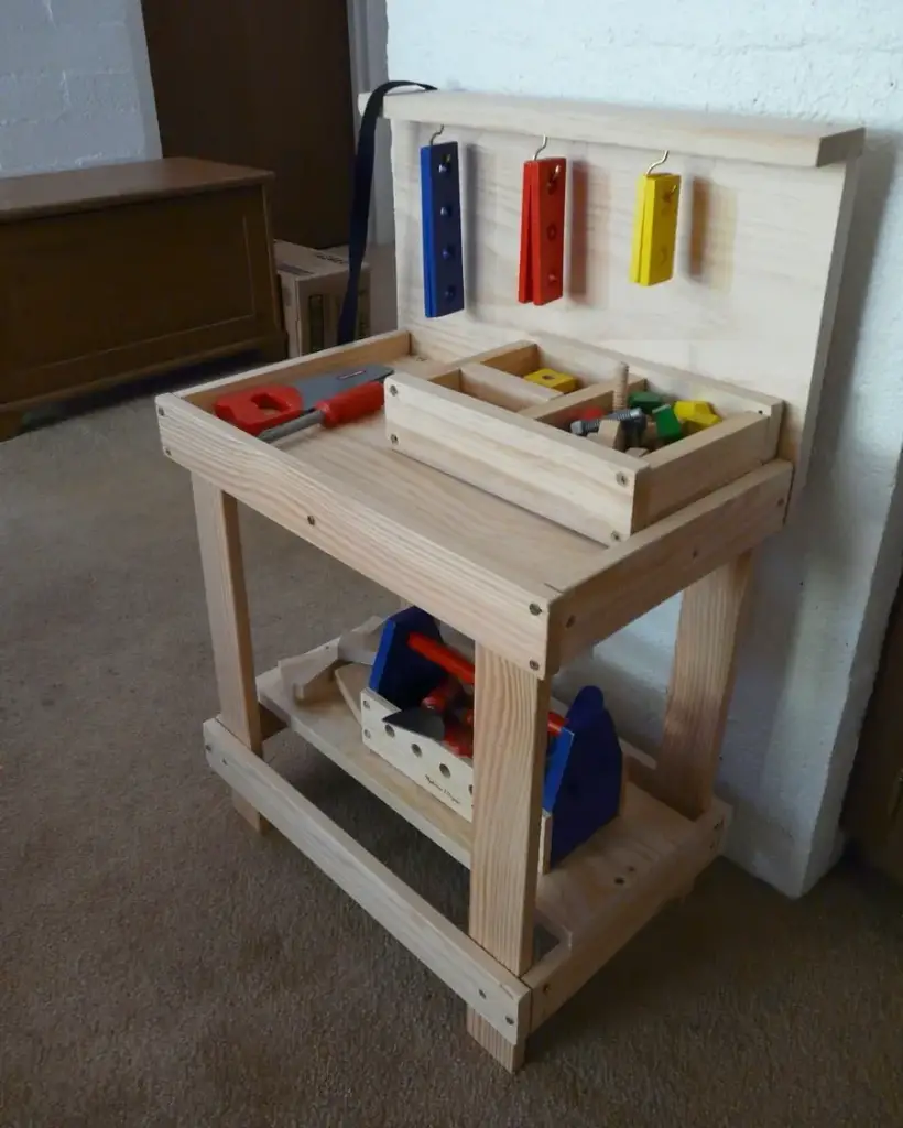 Small pine kids workbench with a tool tray, hanging coloured blocks and a lower shelf of toy tools