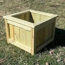 Square treated pine planter box with framed corners and plank sides on grass