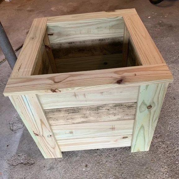 Square treated pine planter box with a framed top rim and corner posts