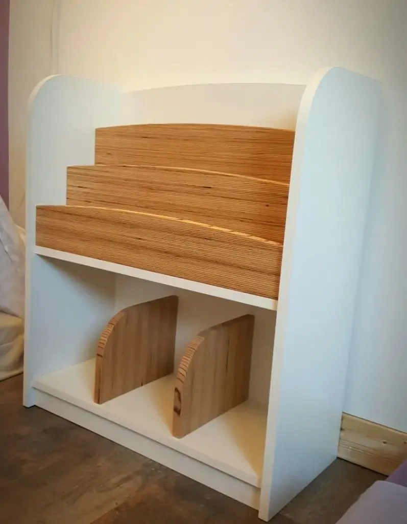 White kids' bookshelf with stepped birch plywood book tiers and plywood bookends below